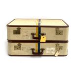A pair of vintage suitcases, each initialled W.H.E, and painted with blue and yellow stripes, with