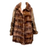 A ladies fur coat with quilted sleeves, approximately size 10