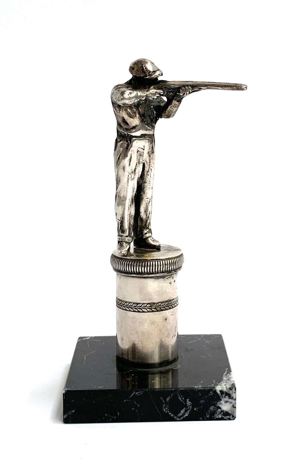 A silver plated shotgun shooting trophy, modelled as a marksman on a plinth with laurel frieze, on