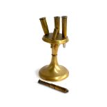 A trench art brass stand holding four shell cases enclosing miniature knife and cross