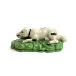 A Staffordshire figure of a recumbent dog, 13.5cmL