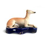 A Staffordshire recumbent greyhound pen holder, 17cmL