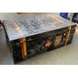 A metal travel trunk with hinged lid and travel stickers, double red and yellow stripe, 89x54x33cm
