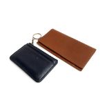 A tan leather Coach wallet and navy purse with zip