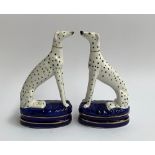 A pair of 20th century Staffordshire seated greyhounds, with spot decoration, 21.5cmH