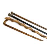 Four walking canes, one with tigers eye knop, one ebonised with chased metal knop and two others