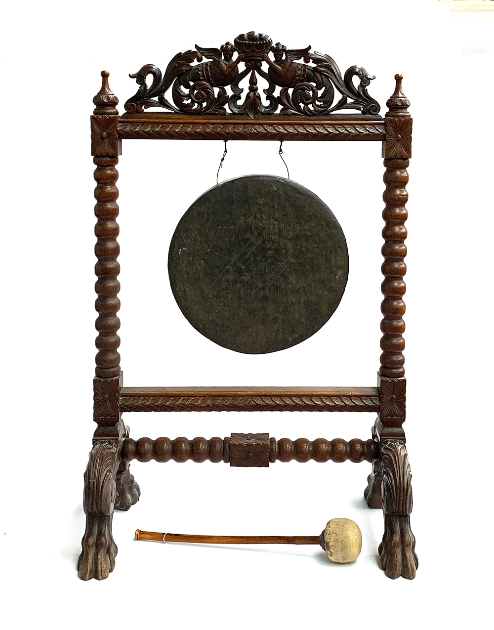 A Victorian oak and brass dinner gong, surmounted with pierced carved scrolls and a pair of mythical