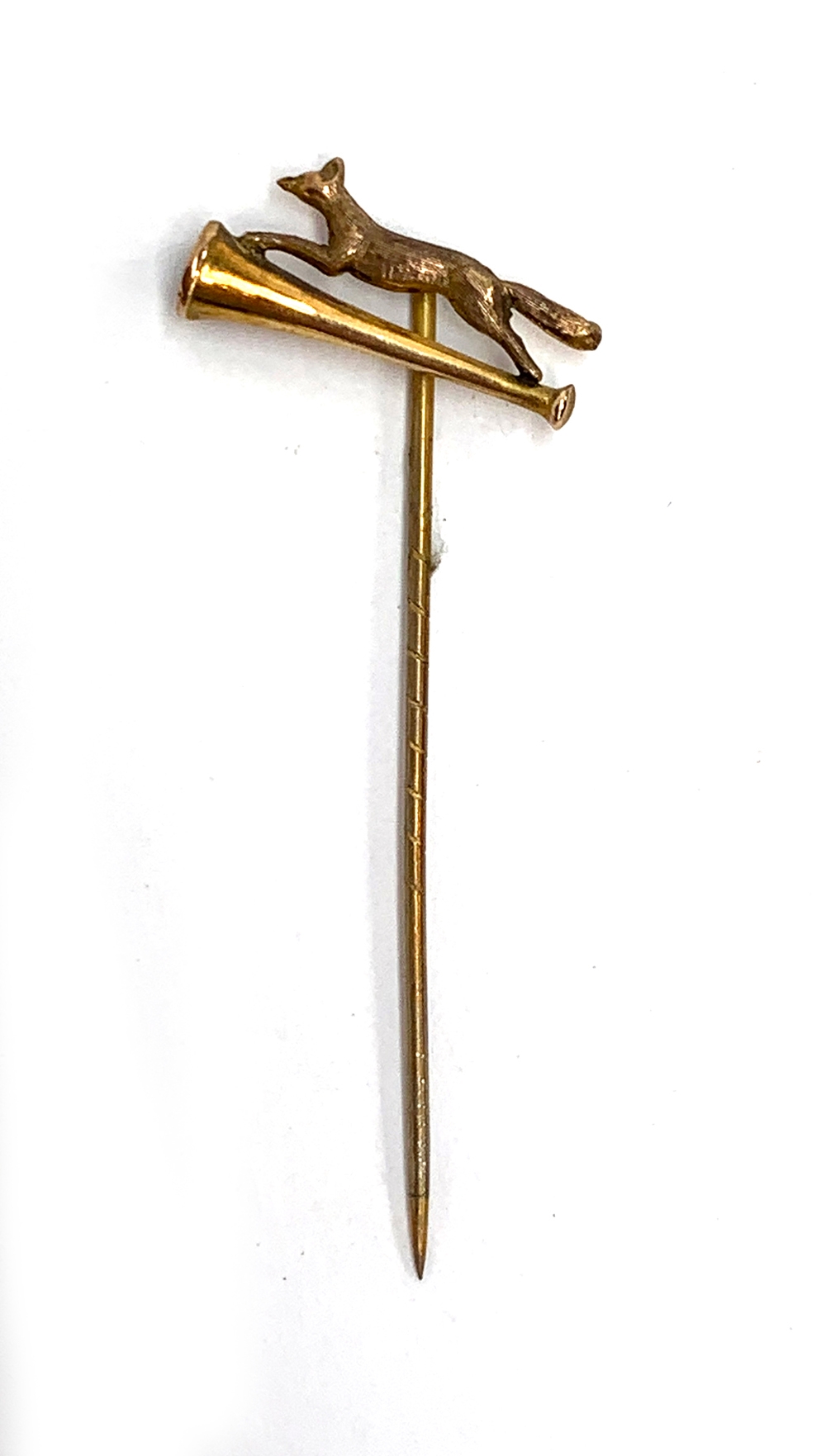 A 9ct gold tie pin depicting running fox above hunting horn