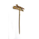 A 9ct gold tie pin depicting running fox above hunting horn