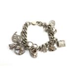 A hallmarked silver charm bracelet with ten charms, approx. 87g