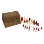 A collection of red and white ivory Chinese chess pieces, in a wooden box