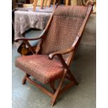 An Arts and Crafts style cross-frame open armchair, hammock back and overstuffed seat (af)