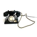 A black rotary dial telephone, wired to work