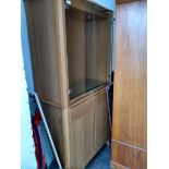 A modern Ercol display cabinet, with glazed doors over two drawers and further cupboard doors,