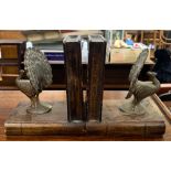 A pair of brass and carved wood peacock bookends