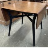 A mid century G-plan dropleaf table on black painted splayed legs, joined by X-stretcher,