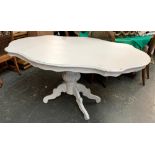 A white painted dining table, the shaped top on acanthus carved pedestal central support,