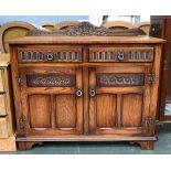 An oak sideboard, two drawers over cupboard doors, carved decoration, 107x46x84cmH