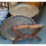 An Indian brass tray on folding stand, 59cmD; together with one other similar