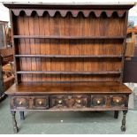 An 18th century oak dresser base, comprising three geometric drawers on baluster and block turned