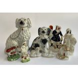 A collection of Staffordshire flatback figurines, to include dogs; figural spill vase; cow; sheep