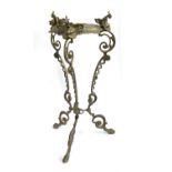 A cast metal pot stand, on three scrolling supports, with pad feet, 59cmH