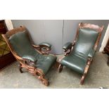 A pair of carved mahogany and green leather armchairs (af)