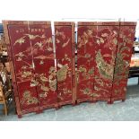 A pair of Chinese threefold lacquered screens depicting songbirds, peacocks and cranes, each panel
