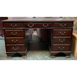 A kneehole desk, cloth skiver, over nine drawer, on ogee bracket feet, 138x81x78cmH