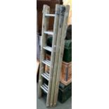 A wooden three piece extending ladder, with aluminium rungs