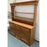 A 19th century pine kitchen dresser, the top with two shelves, the base with two drawers over two
