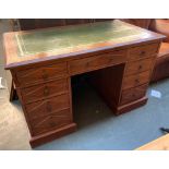 A 20th century oak pedestal desk with green leather skiver, above the traditional arrangement of