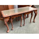 A nest of three tables with glass inset tops, the largest 98cmW