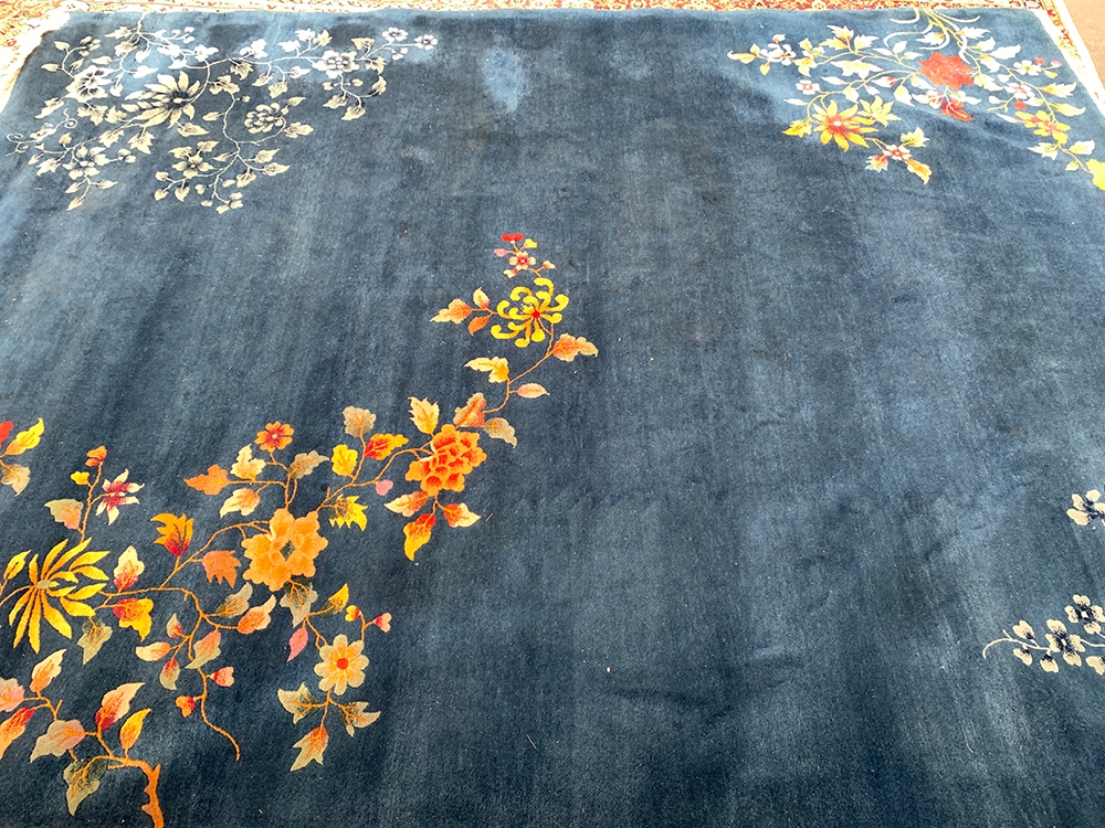 A large blue wool rug with floral decoration, 360x277cm