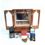 A small mirrored jewellery cabinet containing a small quantity of jewellery, including a white metal