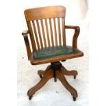 An early 20th century oak swivel desk chair, on casters