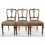 A set of three walnut and ebonised occasional chairs, reeded tapered legs, with stuffover seats