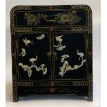 A black japanned cabinet, comprising single drawer and two cupboard doors, depicting songbirds and