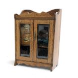 A small glazed oak cabinet, the interior with 2 drawers and shelves, stamped 'Series Made in