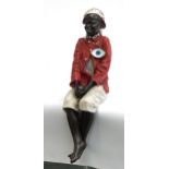 A pottery figure of a sitting boy wearing a red jacket and cap, approx. 50cmH