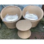 A pair of plastic wicker garden chairs, with stool and cushions