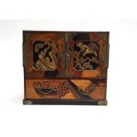 A small Japanese marquetry and lacquer cabinet, the exterior depicting in gilt birds of prey amongst