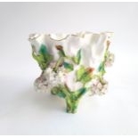 A continental ceramic majolica vase with encrusted floral decoration, the feet in the form of vines,