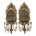 A pair of 19th century Adams style giltwood girandole mirrors, of oval form with gilded gesso wood