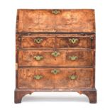 A George I walnut bureau, the cross banded fall front opening to an arrangement of pigeonholes and