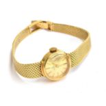 An 18ct gold Tissot ladies wrist watch with gold dial, baton numerals and woven strap, clasp stamped