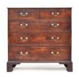 A George III oak chest of drawers, the top with applied moulding, two short over three graduating