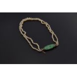 A graduated two row natural pearl necklace (not tested) with carved green jade and gold fastener, of