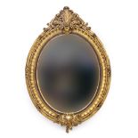 A very large decorative giltwood oval mirror, the beveled plate within moulded frame, with