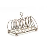 A silver six division toast rack, on gadrooned border and four ball feet, marks unclear, 16cm